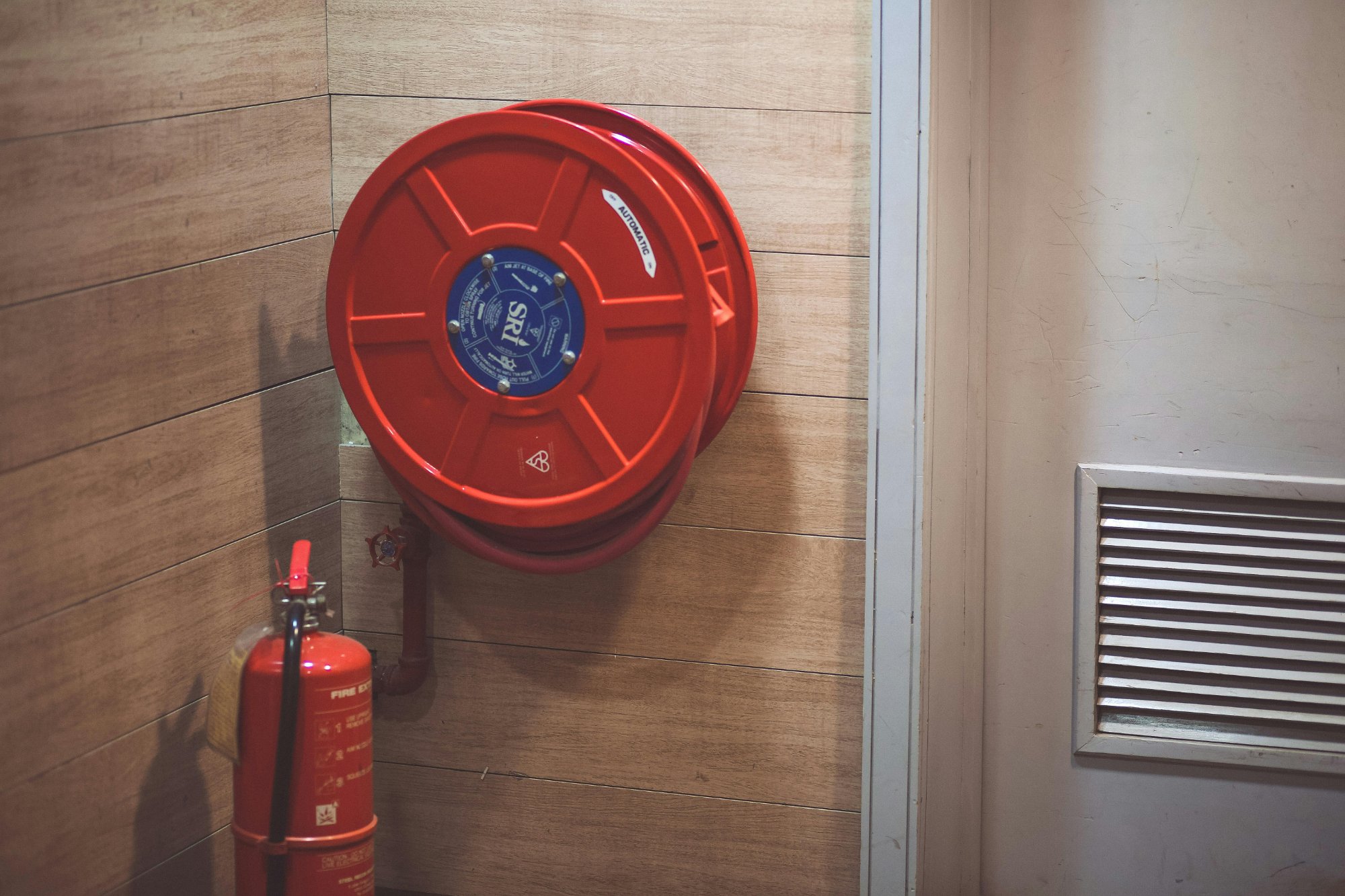 Fire hose reel and extinguisher mounted on wall